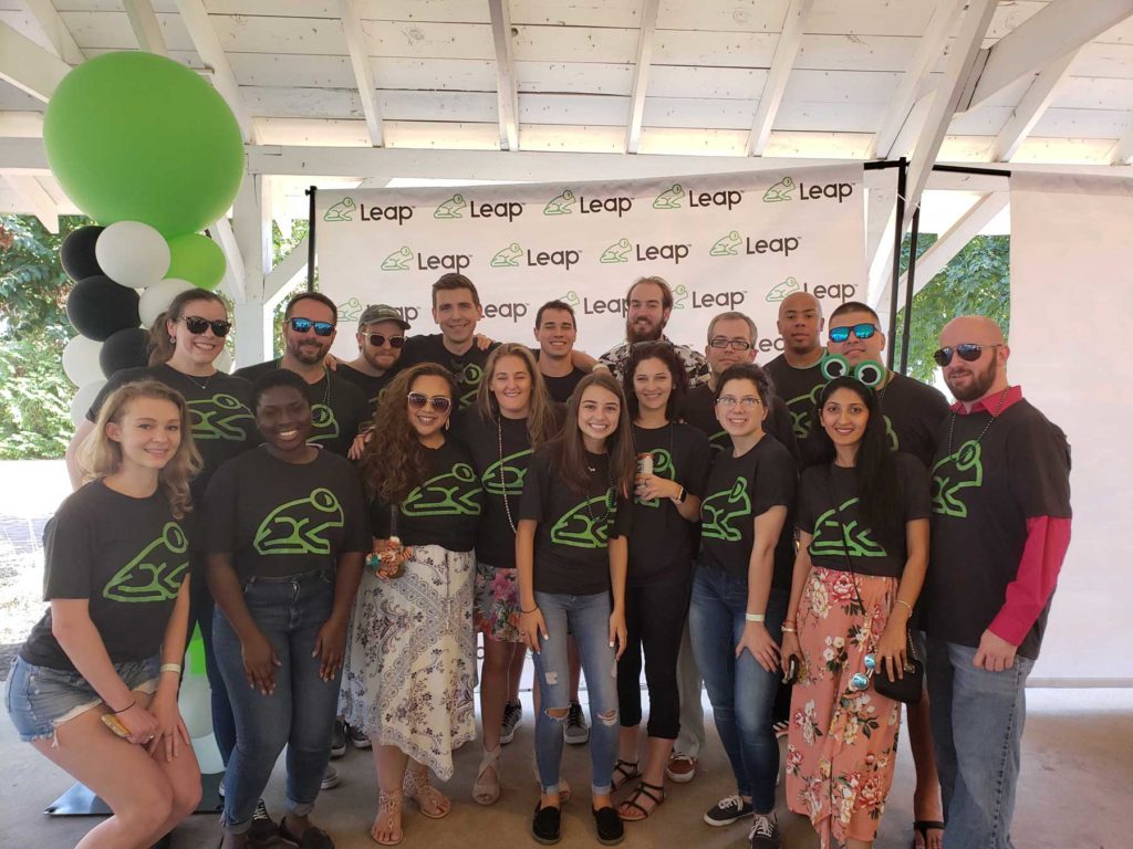 Picture of smiling Leap employees enjoying a beautiful sunny picnic.