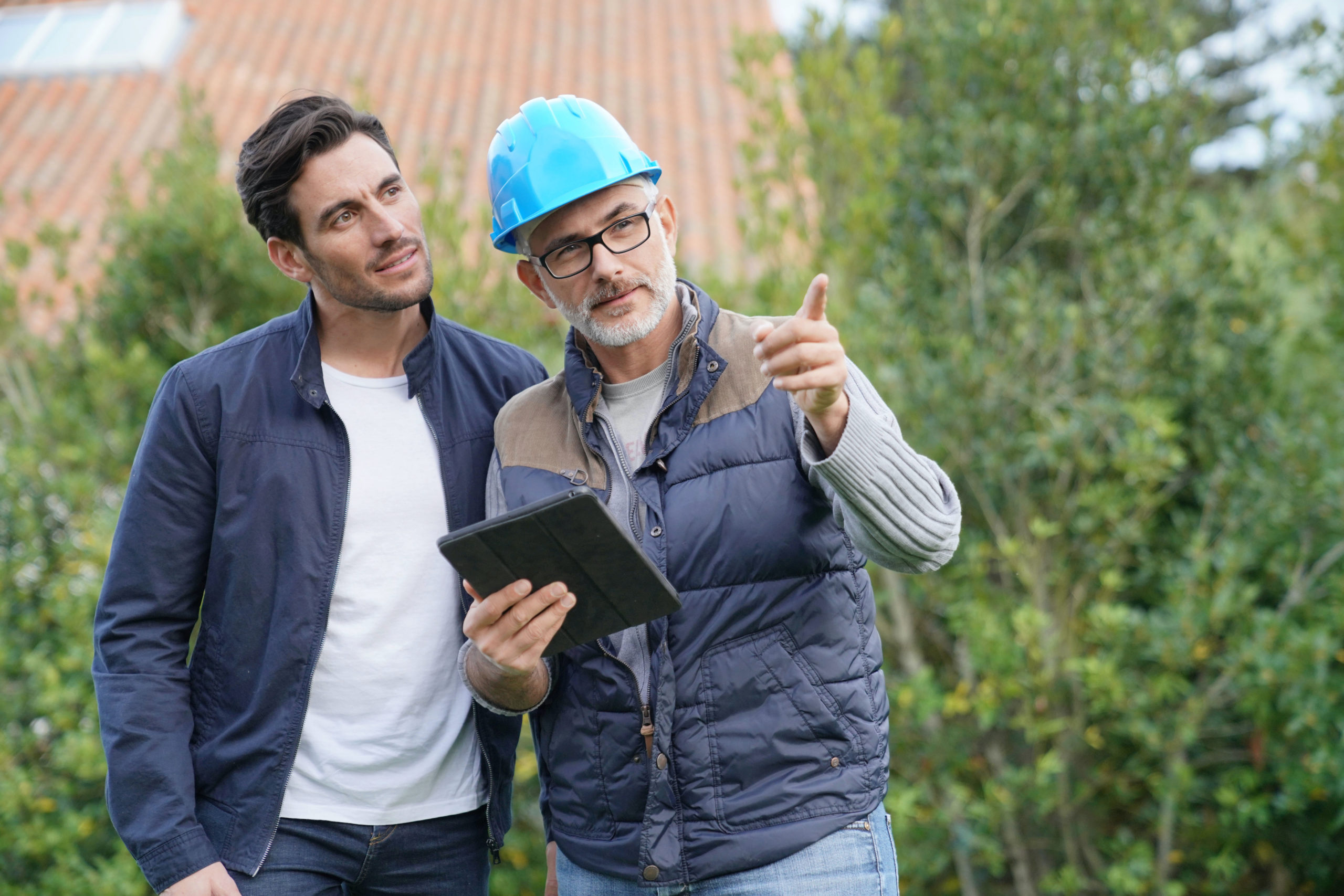 Sale man and homeowner consulting construction plans