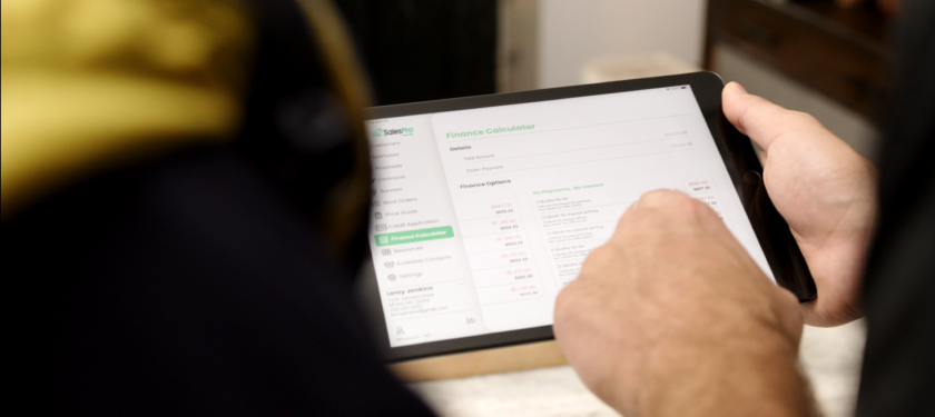 A contractor goes over roof sales training through a tablet