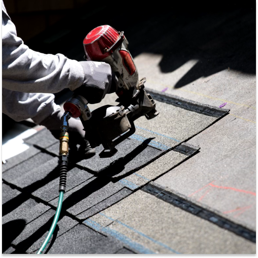 A roofer installing shingles