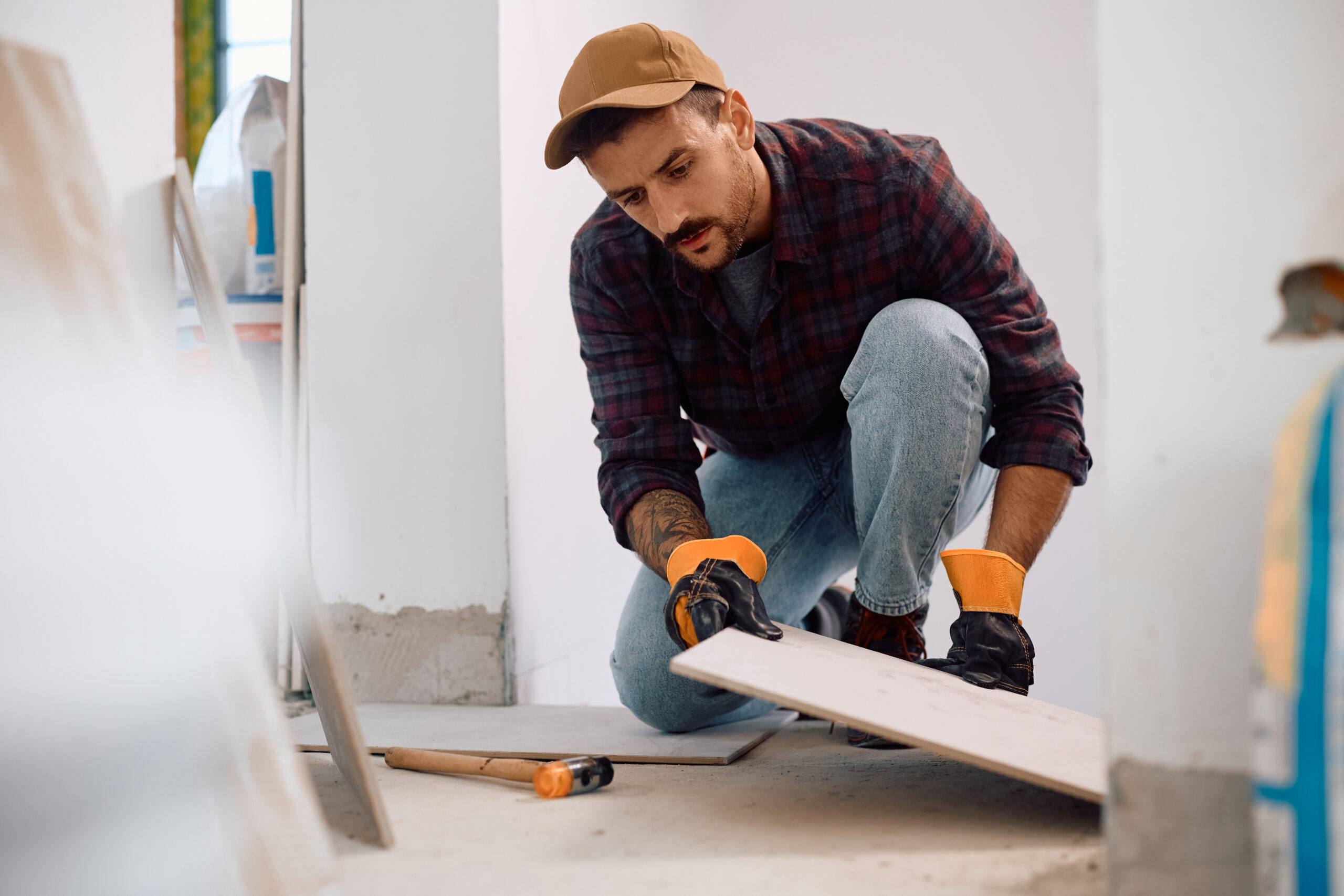 Contractor laying down tiles in a kitchen or bathroom