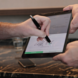 Homeowner signing a SalesPro contract in a kitchen