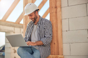 Contractor using CRM software on a laptop at a job site