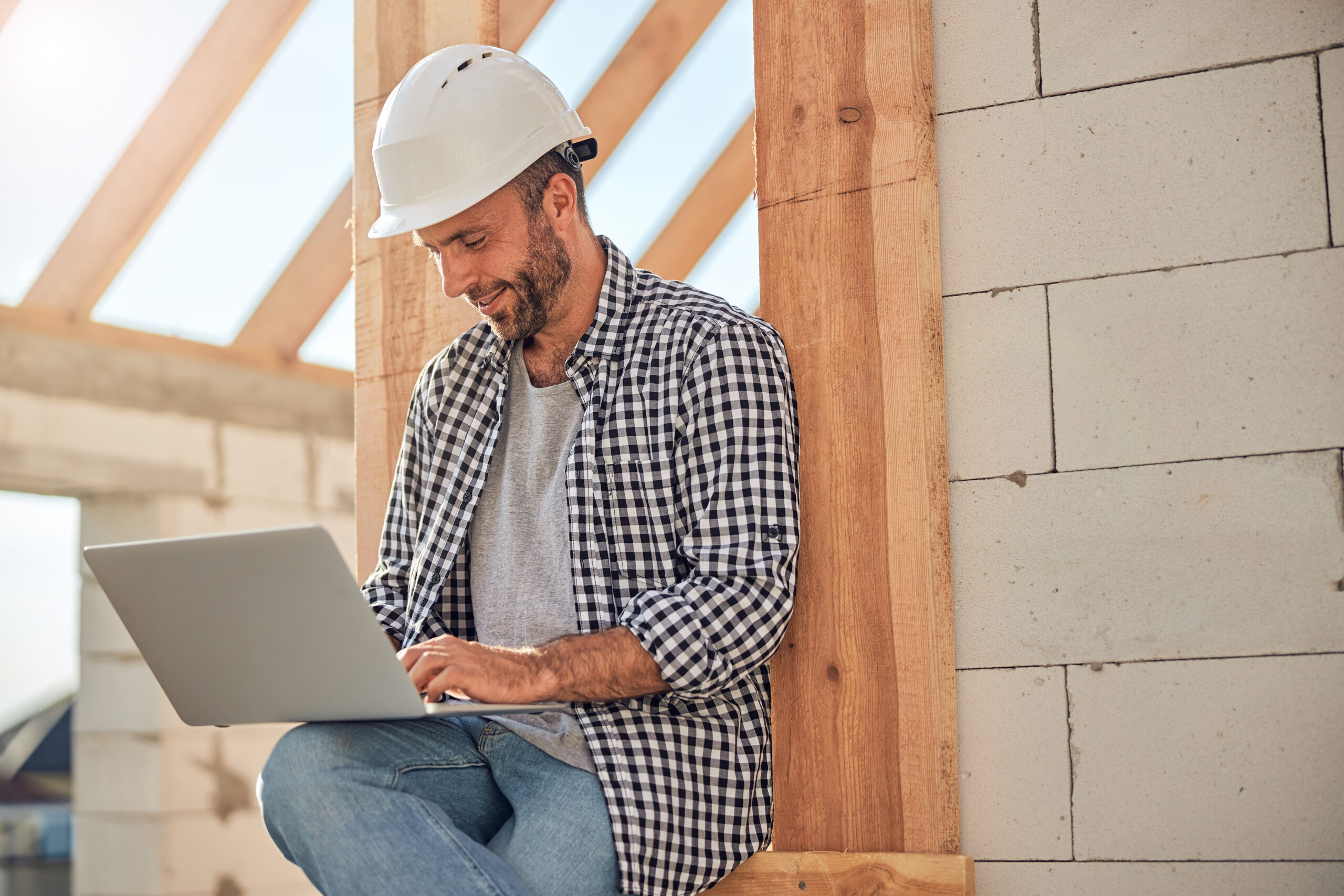 Contractor using CRM software on a laptop at a job site